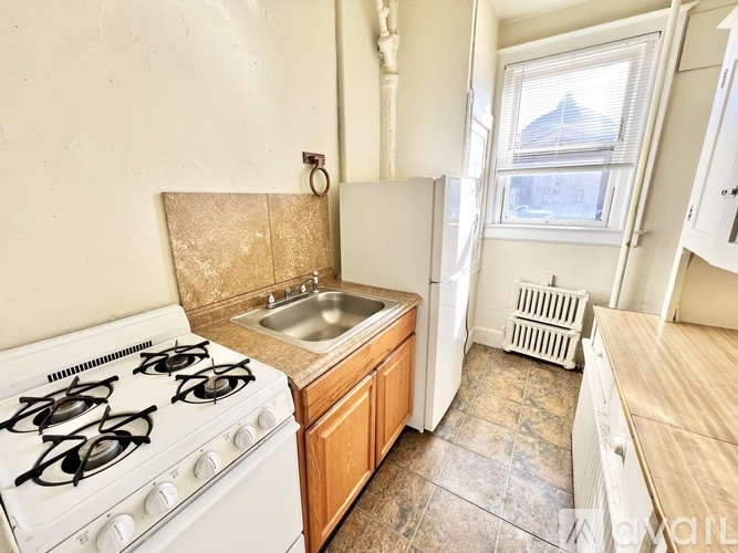 A kitchen with a white gas stove and a sink.