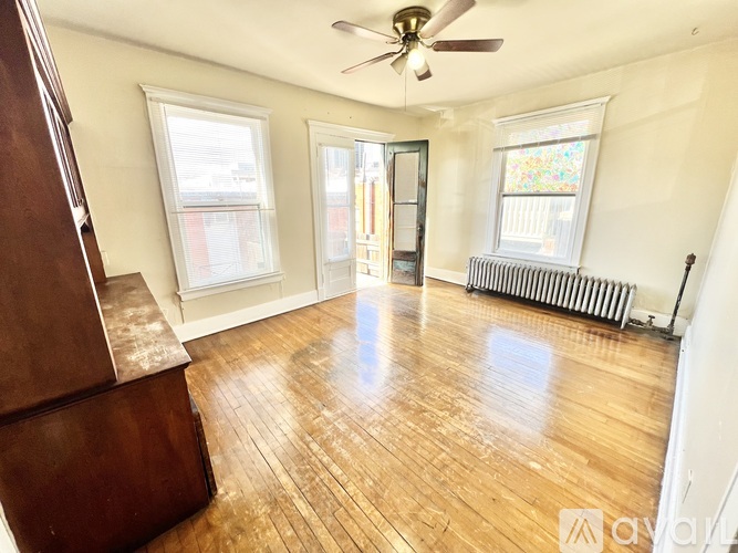 A room with wooden floors and a ceiling fan.