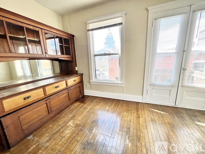 A room with wooden floors and a large window.