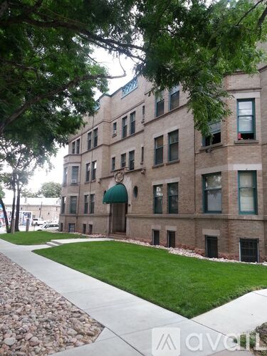 A large building with a green awning sits next to a sidewalk.