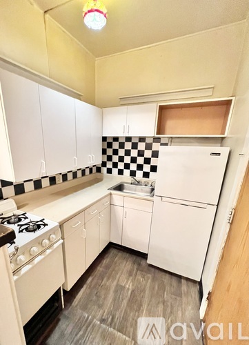 A kitchen with white cabinets and a checkered backsplash.