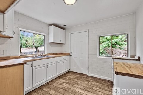 A kitchen with white cabinets and a wooden countertop.