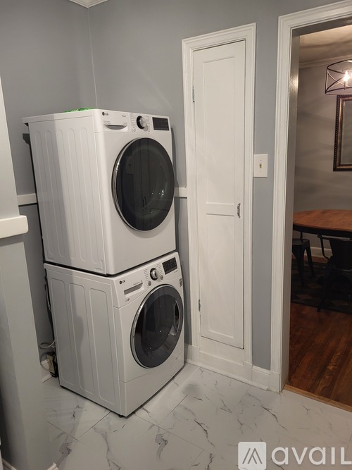 Two white front loading washing machines in a laundry room.