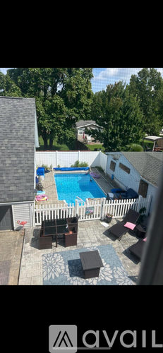 A backyard with a pool and patio furniture.