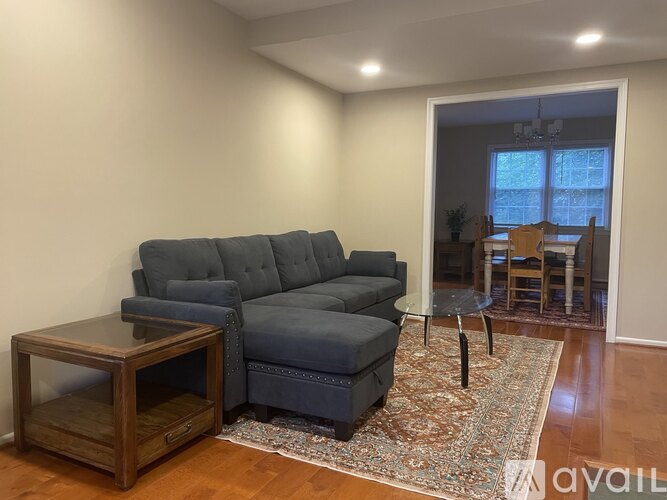 A living room with a grey couch and a wooden table.