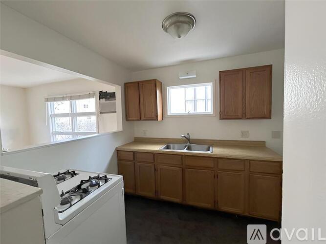 A kitchen with a white stove and wooden cabinets.