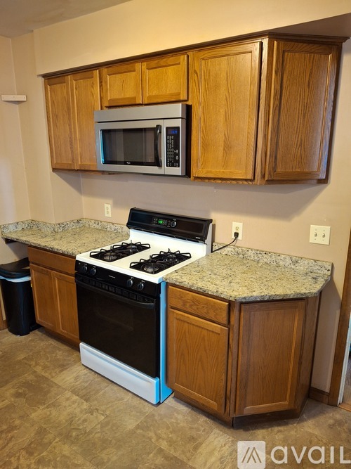 A kitchen with wooden cabinets and a granite countertop.