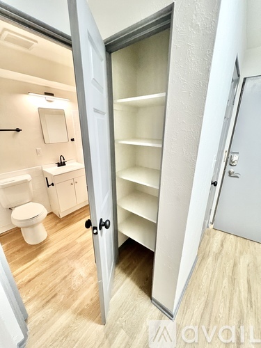 A white bathroom with a toilet, sink, and a white door.