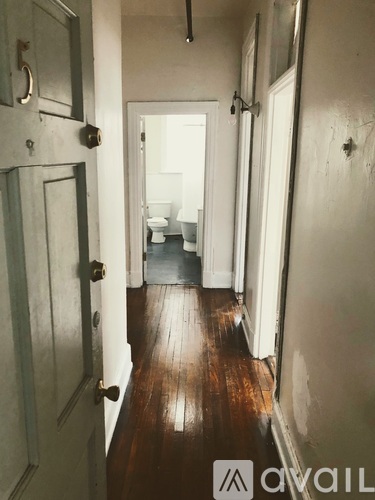 A hallway with a toilet visible in the distance.