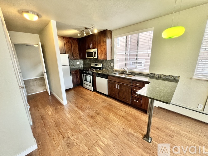 A kitchen with wooden floors and a white refrigerator.