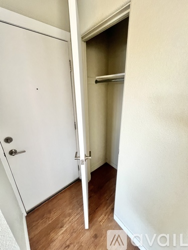 A white door with a handle and a small round hole in the center of the door.