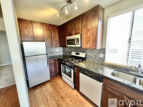 A kitchen with wooden cabinets and stainless steel appliances.
