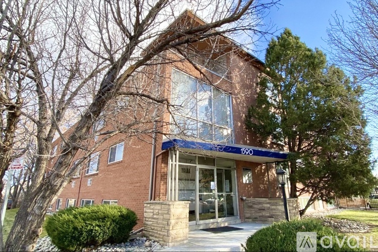 A brick building with a blue awning and glass doors.