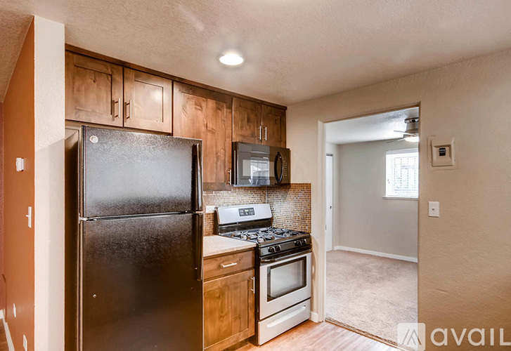 A kitchen with a black refrigerator, stove, and microwave.