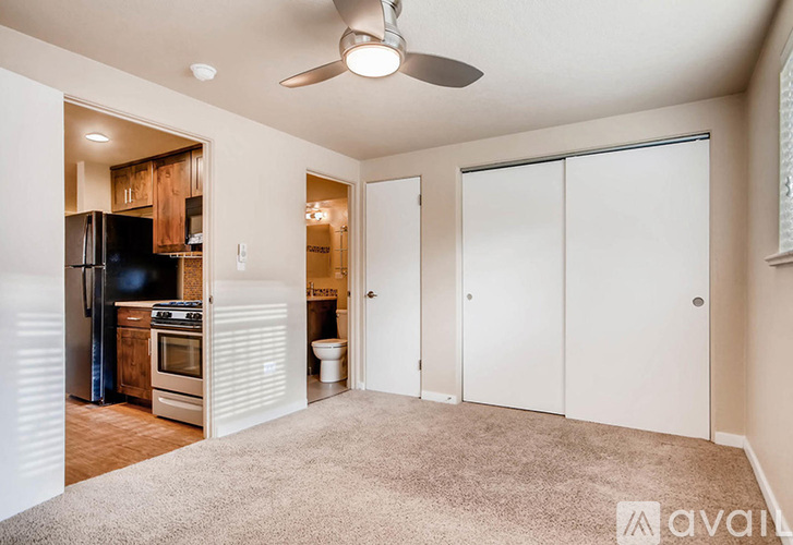 A room with a carpeted floor and a ceiling fan.