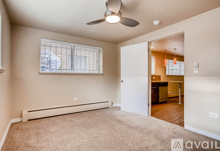 A room with a carpeted floor, a ceiling fan, and a window with blinds.
