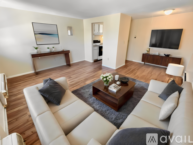 A living room with a white couch and a coffee table in the center.