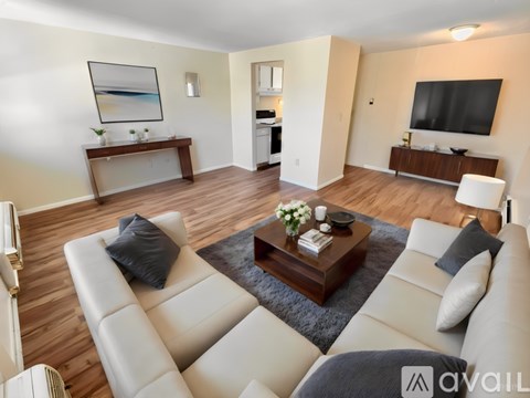 A living room with a white couch and a coffee table in the center.