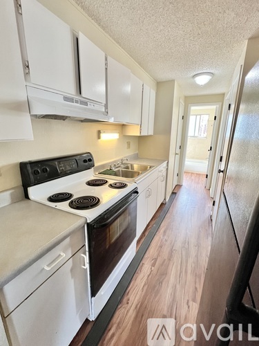 A kitchen with white cabinets and a black stove top.