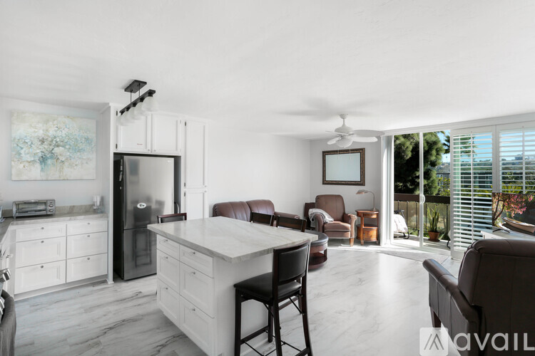 A kitchen with a refrigerator, a stove, and a dining table with chairs.