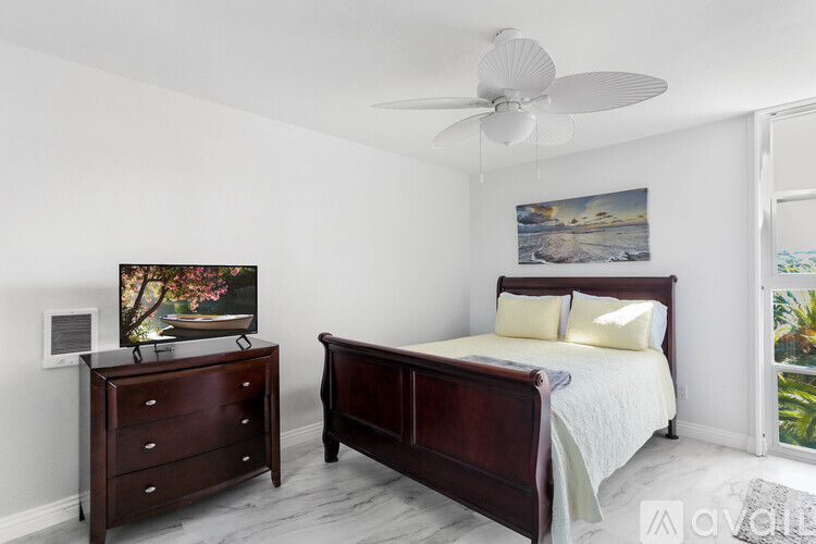 A bedroom with a bed, dresser, and painting.