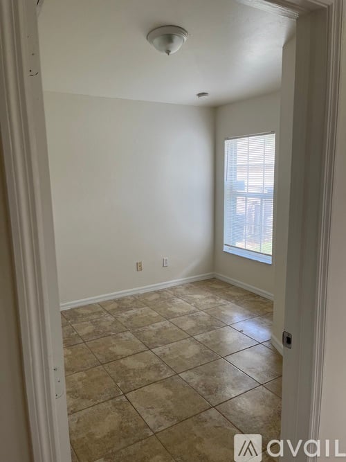A room with tiled flooring and a window.