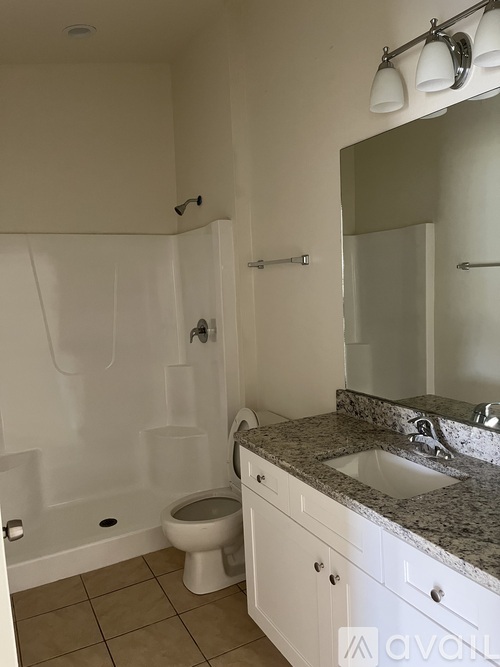 A bathroom with a toilet, sink, and shower.