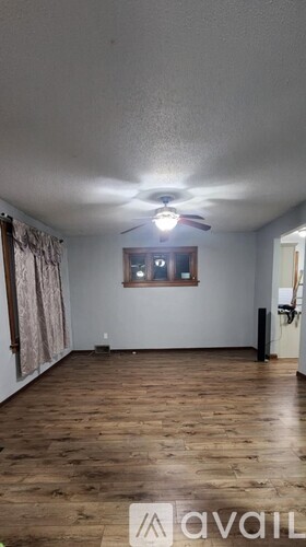 A room with wooden floors and a ceiling fan.