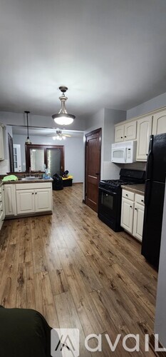 A kitchen with wooden floors and white cabinets.