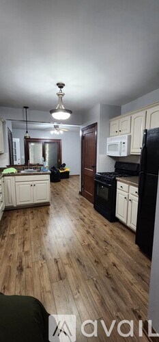 A kitchen with wooden floors and white cabinets.