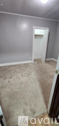 A room with a carpeted floor and a doorway leading to another room.