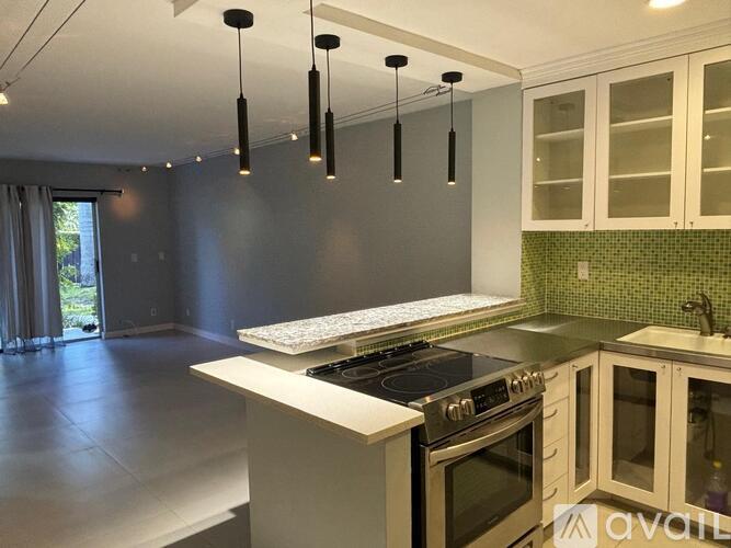 A modern kitchen with a stove top oven and a counter top.