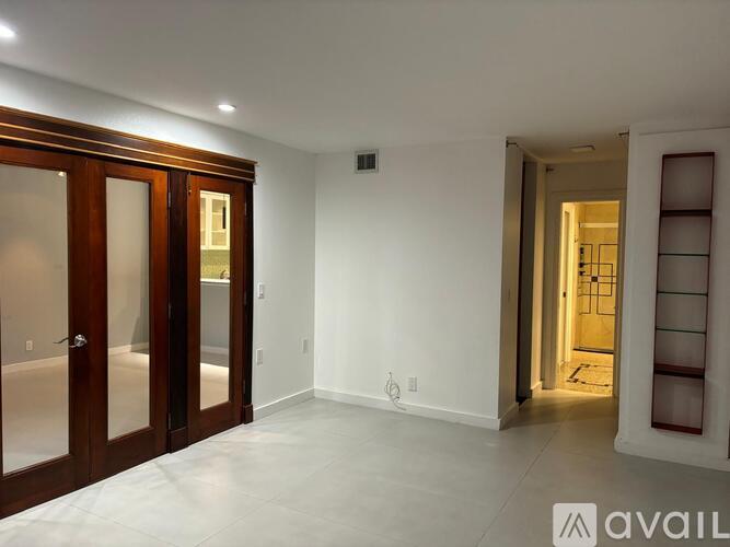 A room with a white wall and a door with a glass panel.