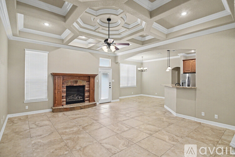 A spacious living room with a fireplace and a fan on the ceiling.