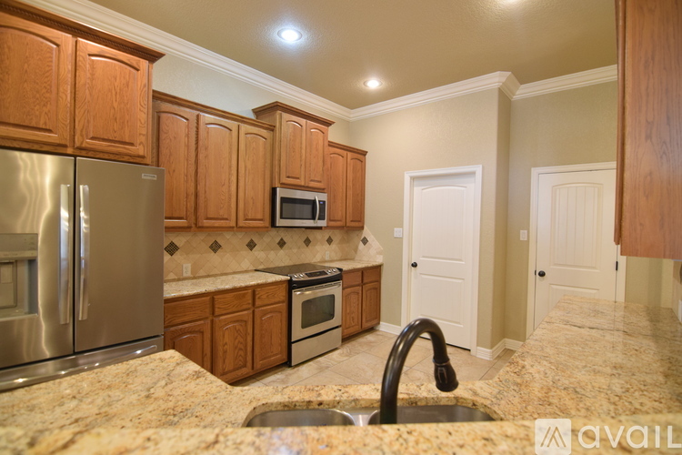 A kitchen with wooden cabinets and a granite countertop.