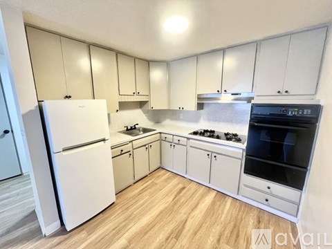 A kitchen with white appliances and cabinets.