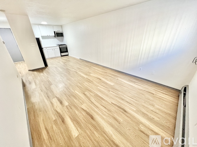 A room with wooden flooring and white walls.