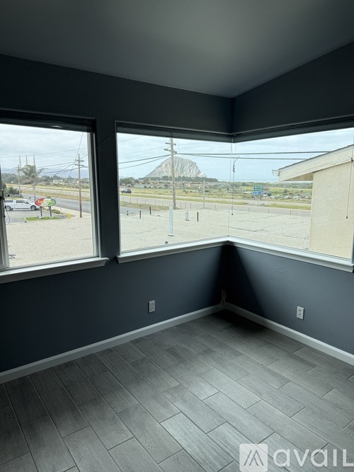 A room with a large window overlooking a parking lot.