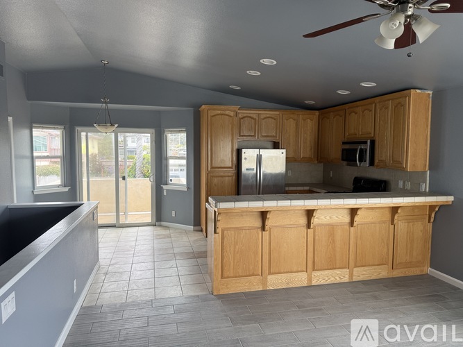 A kitchen with wooden cabinets and a ceiling fan.