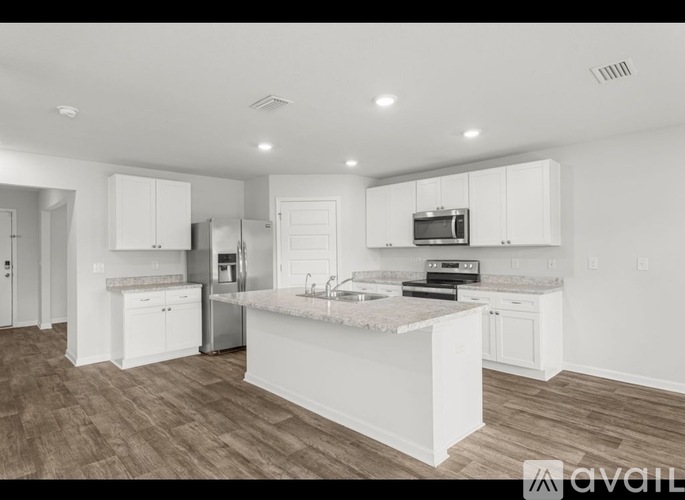 A modern kitchen with white cabinets and a central island.