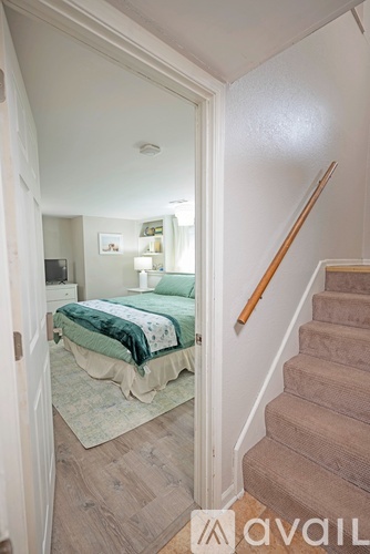A bedroom with a bed and a staircase.