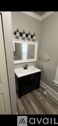 A bathroom with a white sink and a mirror above it.