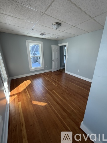 A room with wooden flooring and a window.