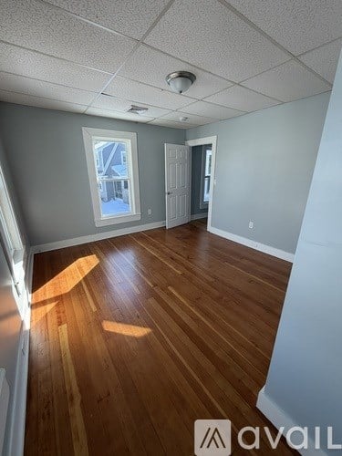 A room with wooden flooring and a window.