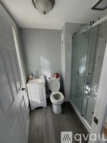 A bathroom with a toilet, sink, and shower.