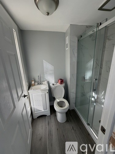 A bathroom with a toilet, sink, and shower.
