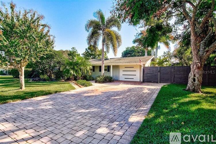 A house with a driveway and trees in front.