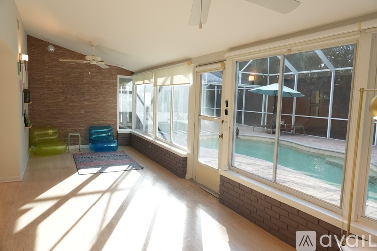 A sunny day in a room with a pool outside.