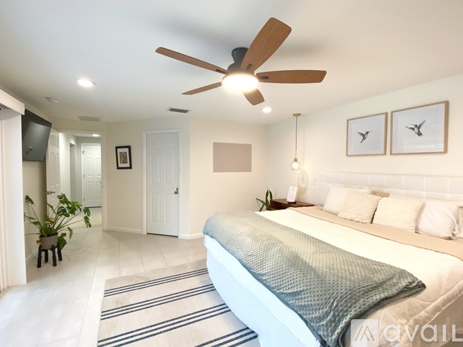A bedroom with a large bed and a ceiling fan.