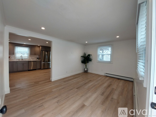 A spacious room with wooden flooring and a window.